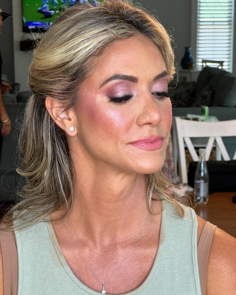 Mulher branca, mais velha, com regata e maquiagem colorida