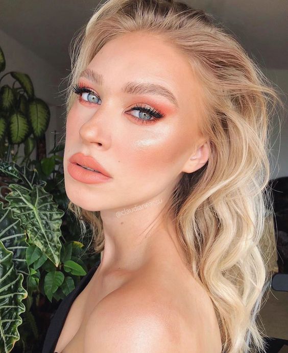 Mulher branca, com cabelo longo loiro e maquiagem pastel laranja