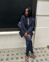 Marilyn usando conjunto de blazer e calça de alfaiataria risca de giz azul marinho, bolsa Chanel matelassê e chinelo Chanel
