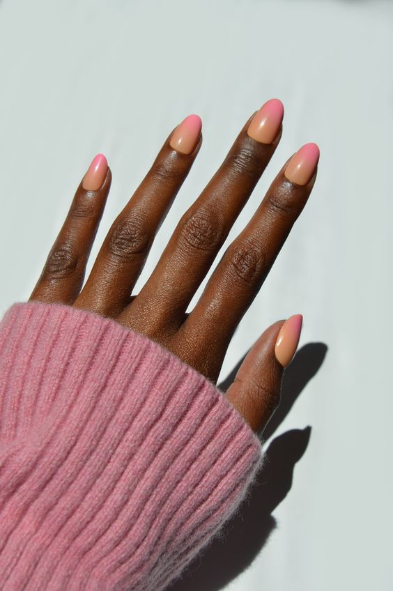 Mão negra com unha amendoada ombré laranja e rosa 