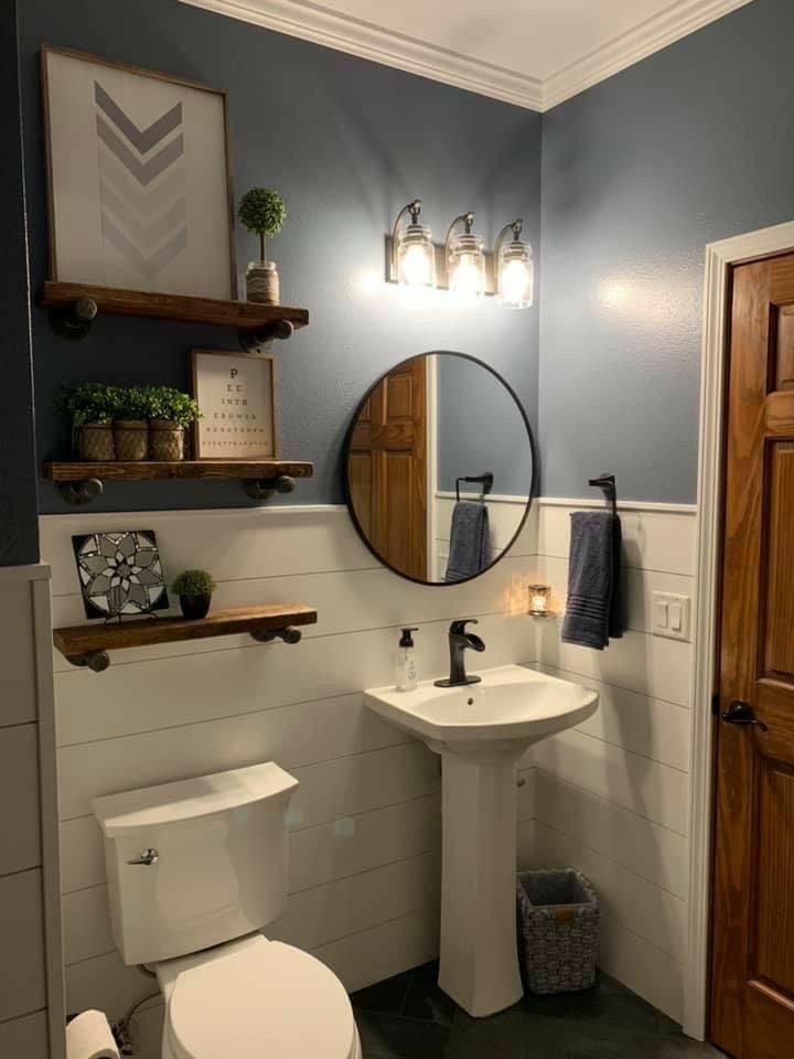 Banheiro branco e azul com prateleiras em madeira natural