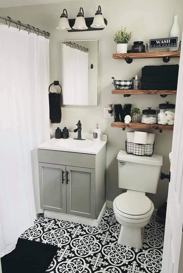 Banheiro em branco, preto e cinza com prateleiras em madeira