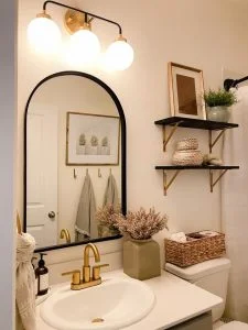 Banheiro branco com detalhes em dourado e preto