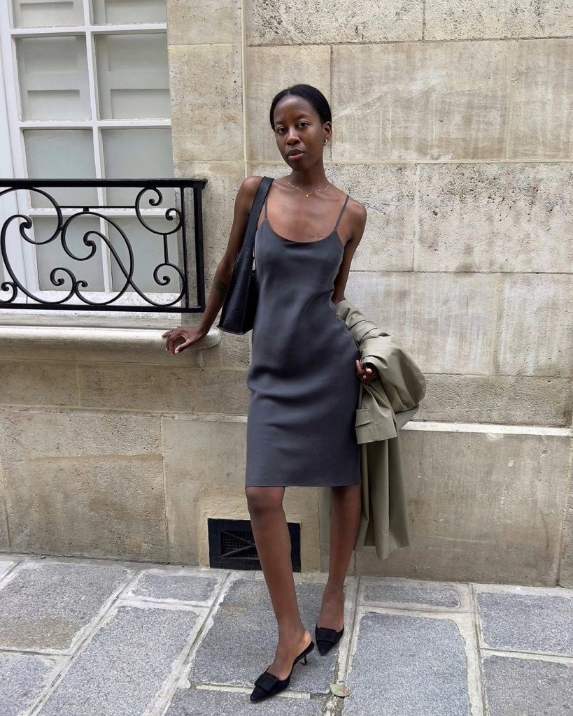 Sylvie Mus com vestido cinza de alça, bolsa preta e mule preto kitten heels de bico preto