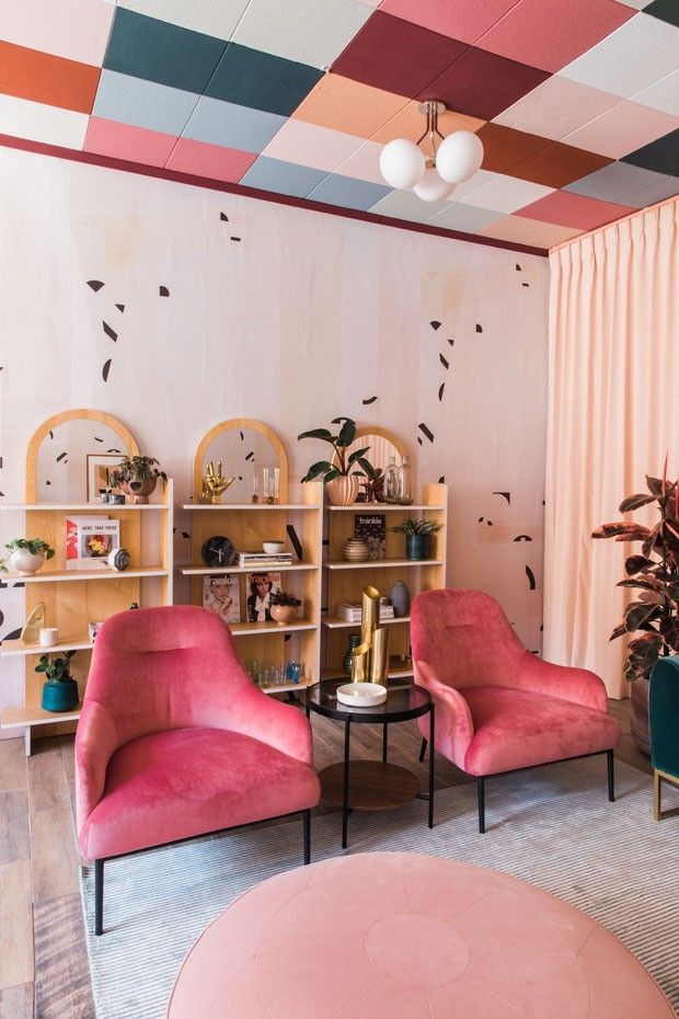 Sala de estar com poltronas rosa e teto quadriculado colorido