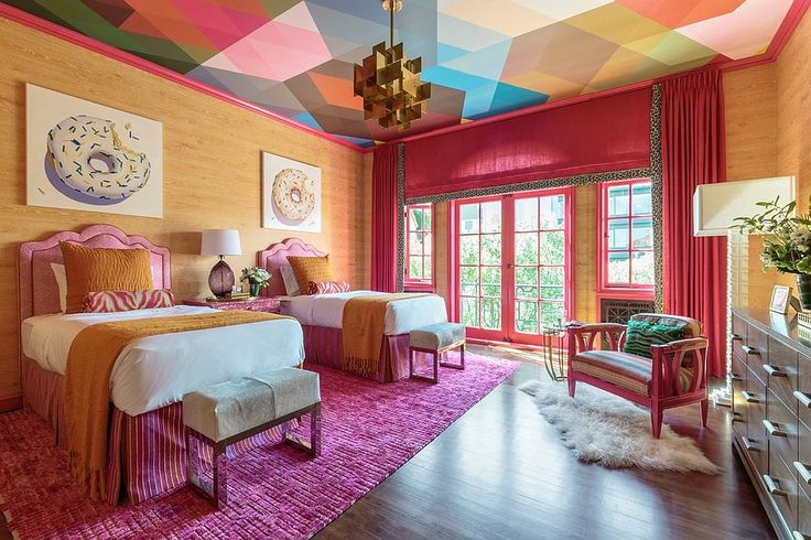 Quarto com estampa geométrica multicolorida com rodateto rosa