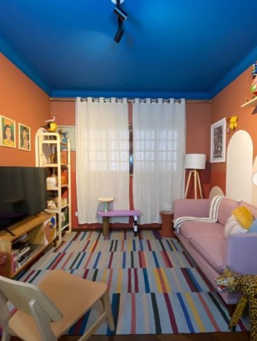 Sala de estar com paredes terracota e teto azul