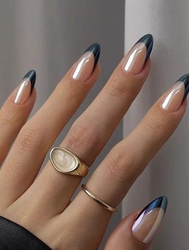 Mão branca com anéis e unha amendoada branca com francesinha azul-marinho perolada