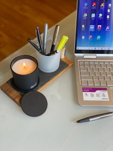 Notebook, vela e porta-canetas