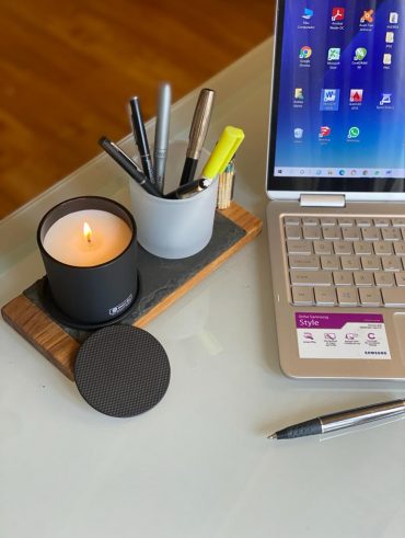 Notebook, vela e porta-canetas