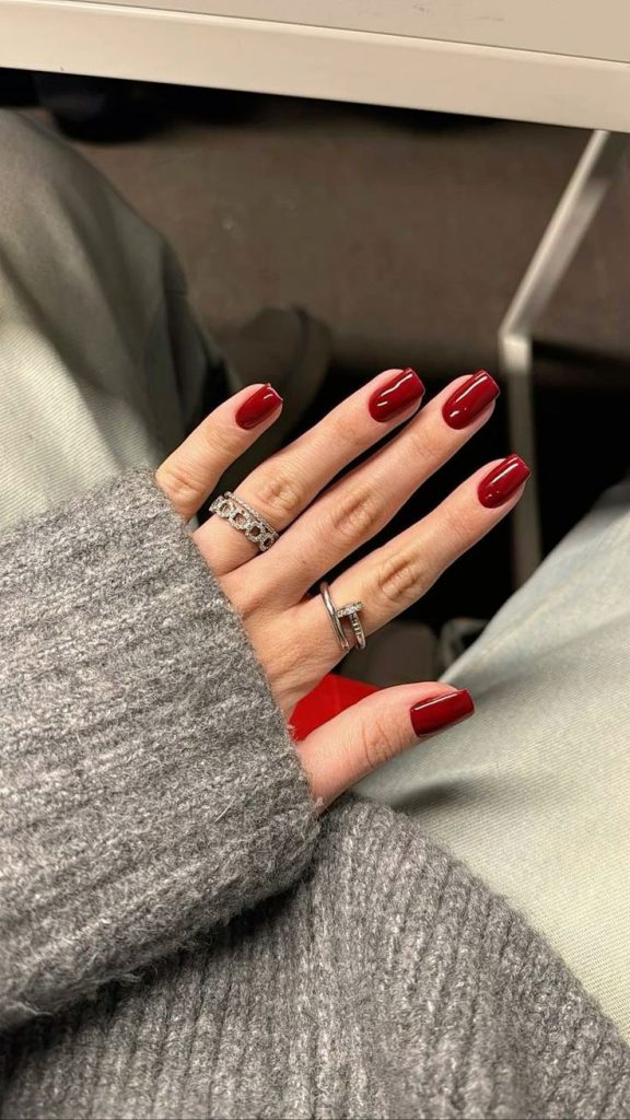 Mão de pele clara com unhas vermelhas