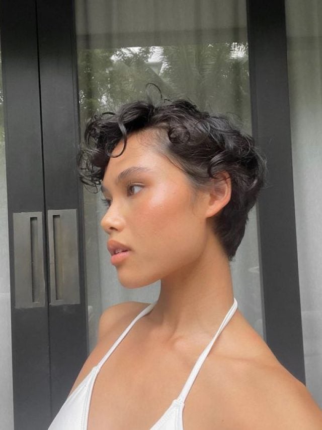 Mulher com corte de cabelo bixie ondulado e maquiagem suave