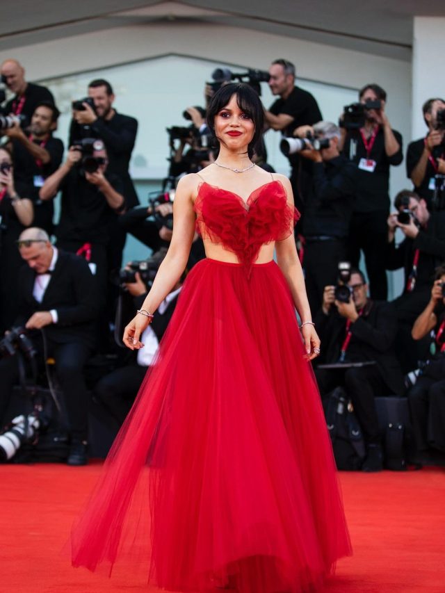 Jenna Ortega em Festival de Veneza. Ela usa vestido vermelho.