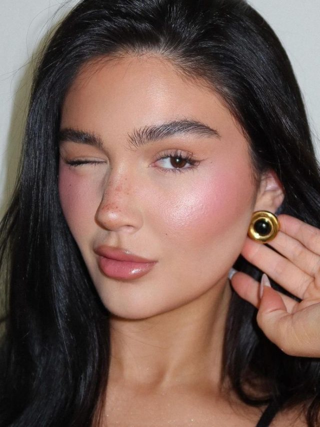 Mulher branca com cabelo escuro, maquiagem clean com blush rosa