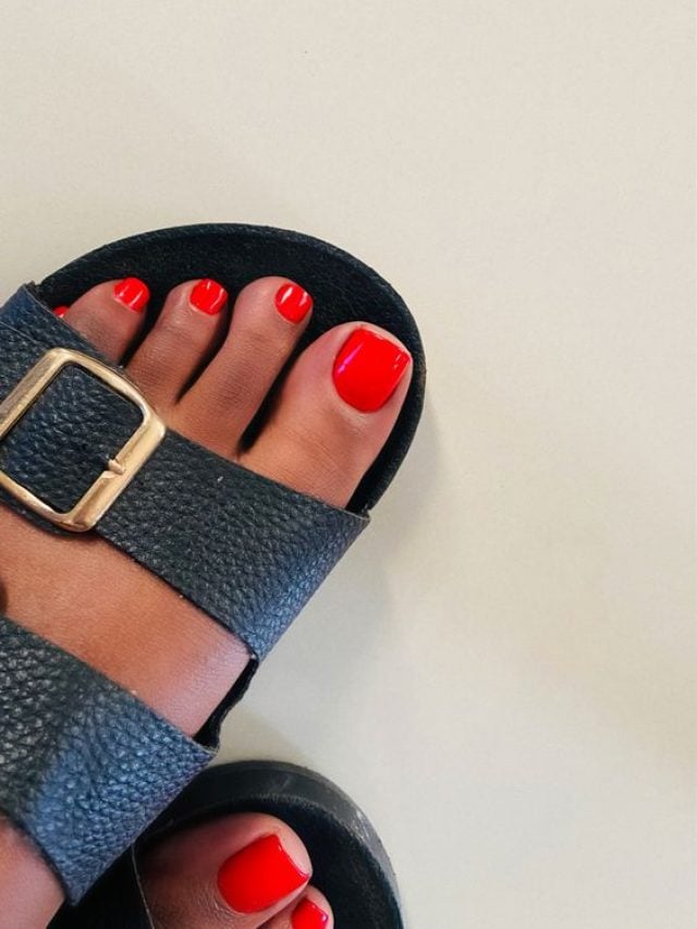 Pés de pele negra, com esmalte vermelho