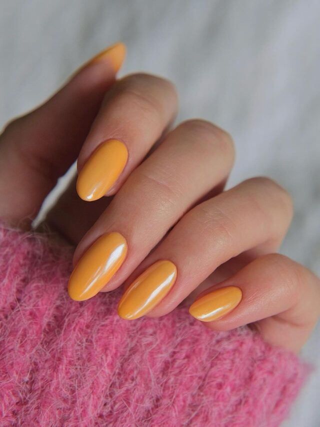 Mão de pele branca, com unha com esmalte laranja