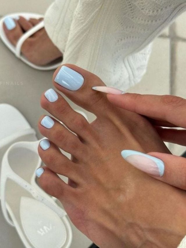 Mãos segurando o pé com unha azul-bebê