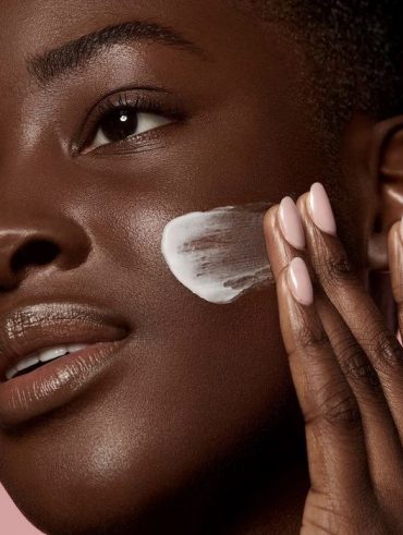Zoom de foto de pele negra de uma mulher jovem com creme hidratante.