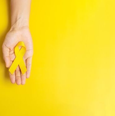 Setembro amarelo: foto de mão branca segurando simbolo amarelo.