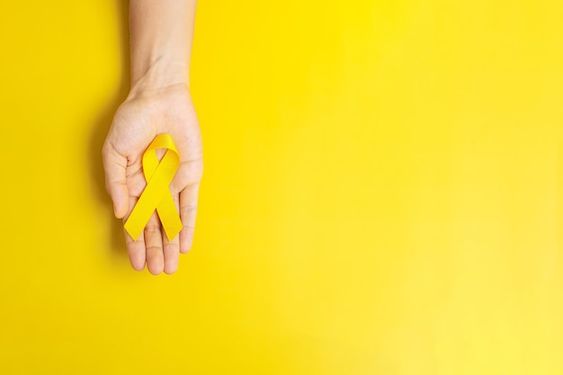 Dia Mundial da Prevenção do Suicídio: foto de mão branca segurando simbolo amarelo. 