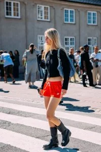 Mulher jovem, magra e de pele clara com look do street style.