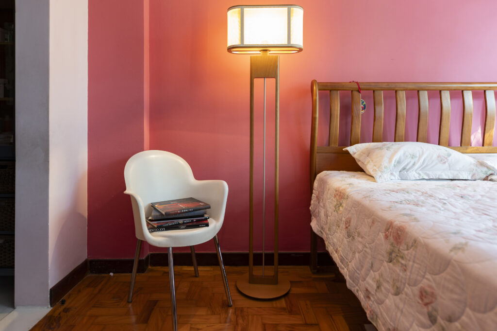 Quarto com parede rosa e luminária de piso grande