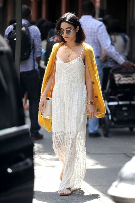 VANESSA HUDGENS usando cardigan laranja e vestido longo na tonalidade branca