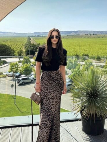 Mulher usando camiseta preta e saia longa de animal print