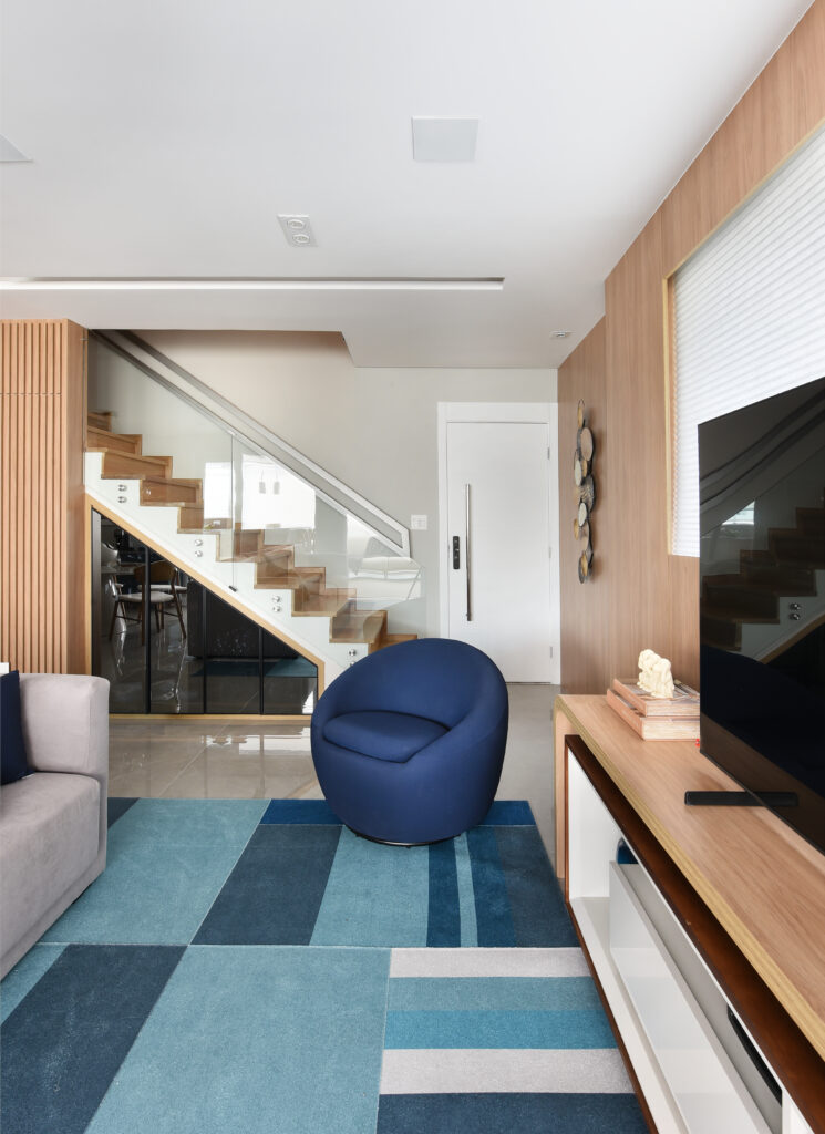 Sala de estar com tapete e poltrona azul