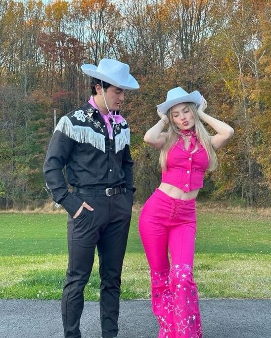 Homem e mulher jovem de pele clara com fantasia de casal de Barbie e Ken