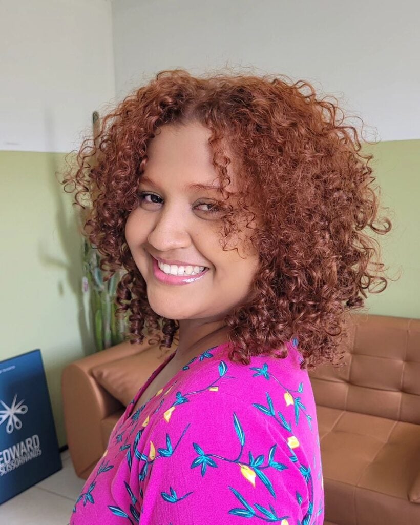 Mulher com corte de cabelo cacheado e com franja