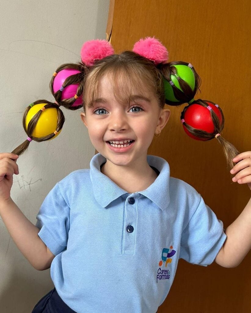 Menina com cabelo maluco, com tranças e bolas