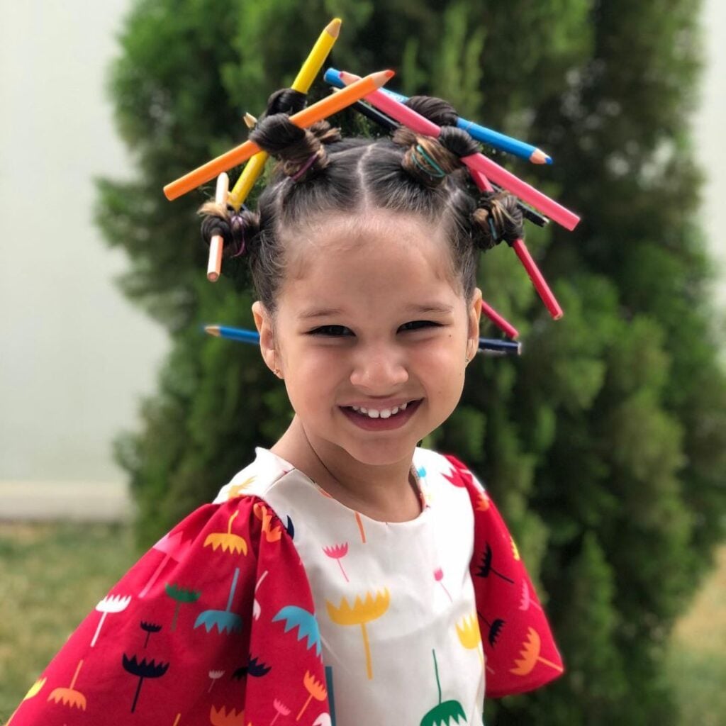 Menina com cabelo maluco com lápis