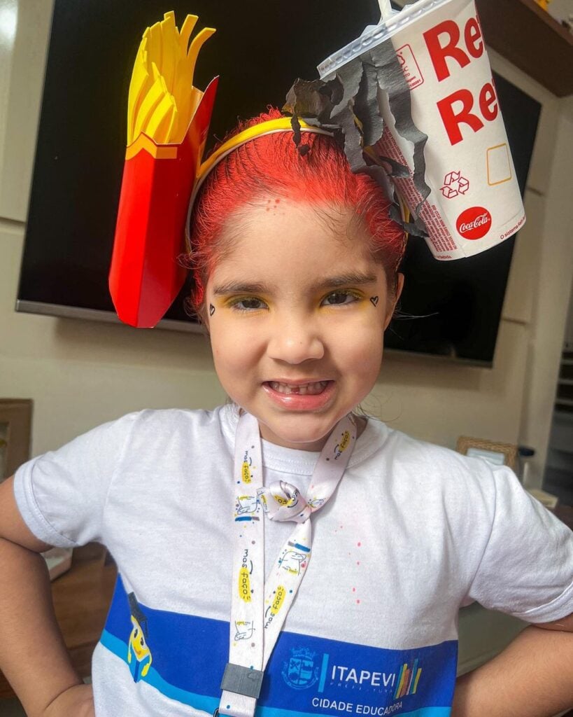 Menina com cabelo maluco de lanche do McDonald's, com refrigerante e batata frita e spray