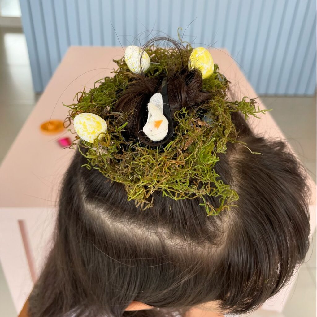 Menina com cabelo maluco de ninho com ovos e pintinho