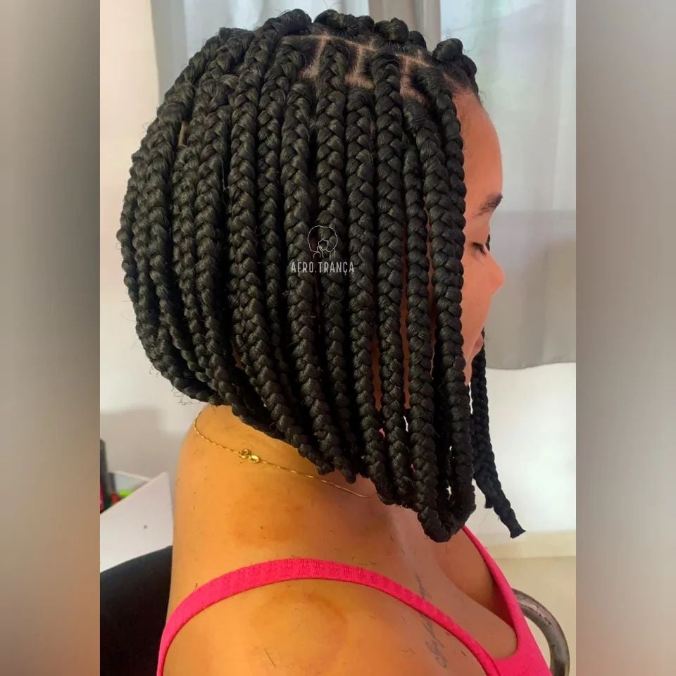 Mulher negra, com cabelo preto e com trança, com corte curto e chanel de bico