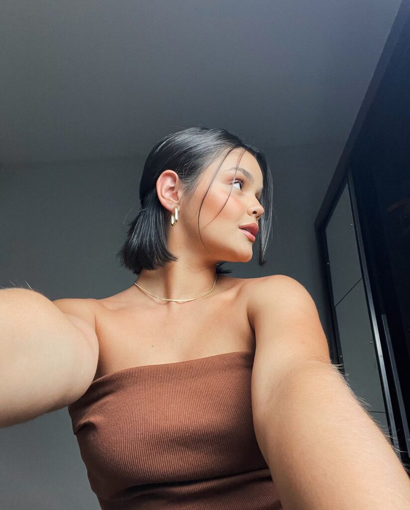 Mulher, com cabelo preto, com corte curto e chanel