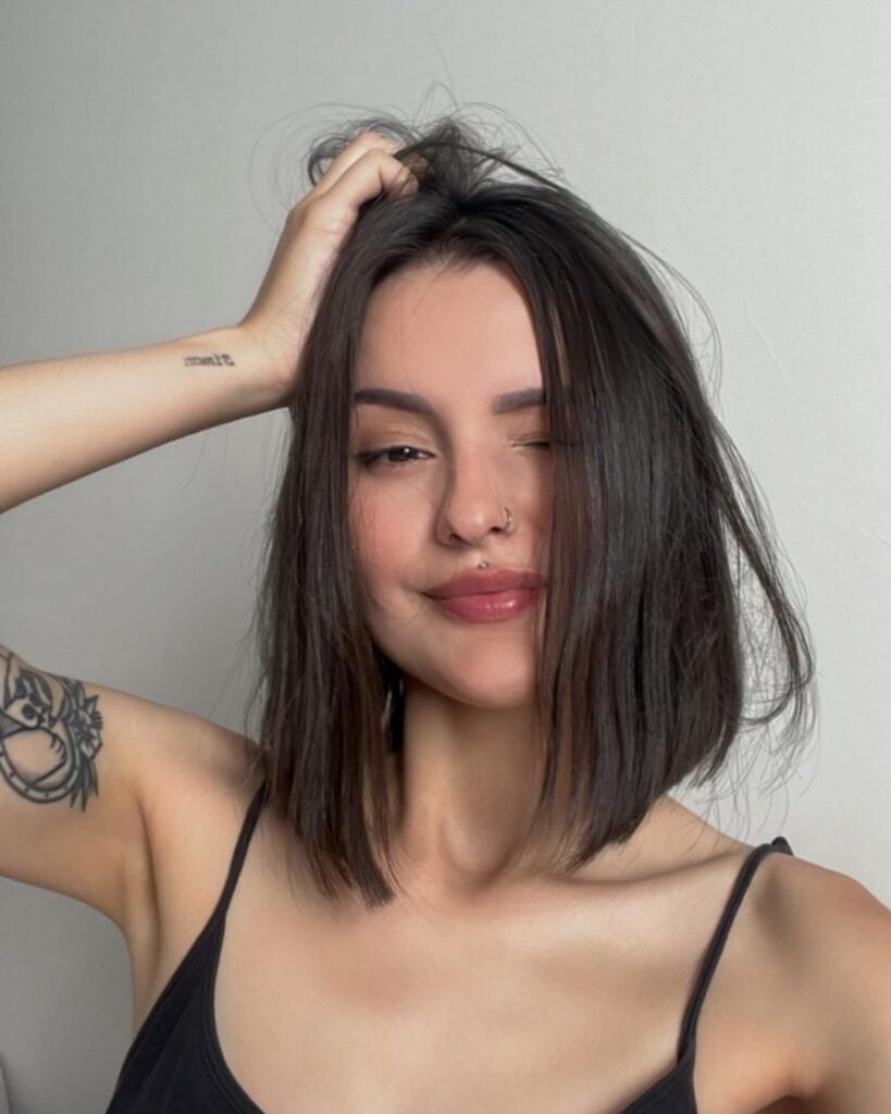 Mulher branca, com cabelo castanho, com corte curto e chanel