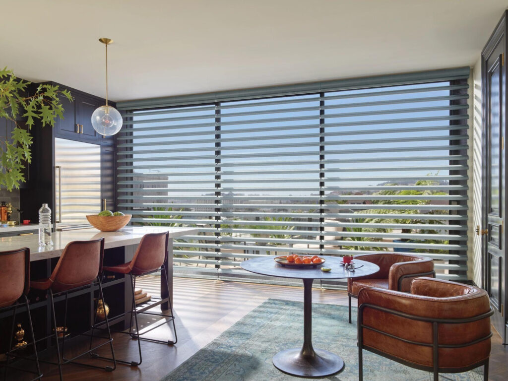 Ambiente com poltronas de couro e cortinas persianas