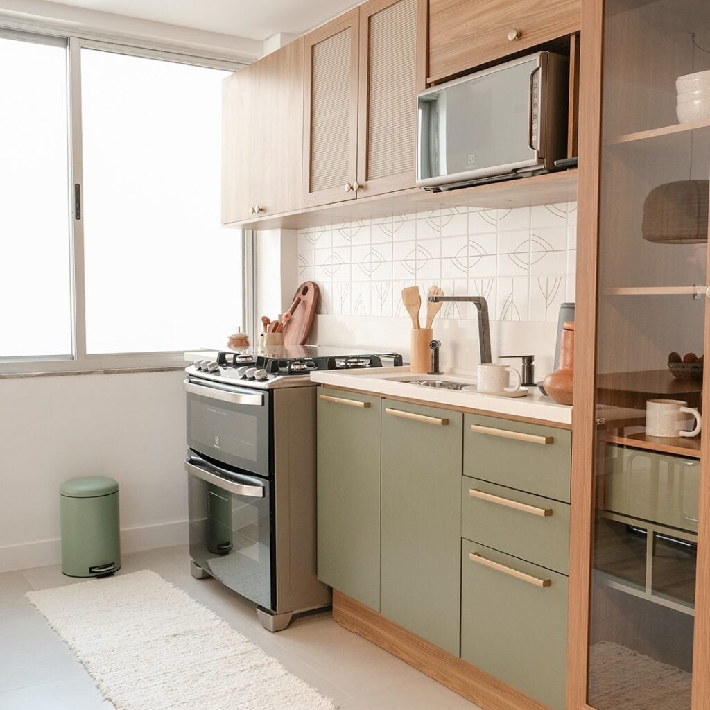 Cozinha verde-menta e MDF que remete à madeira, com fogão e mesa
