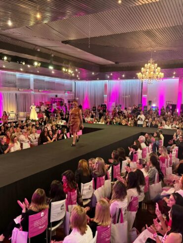 Passarela com desfile e público grande