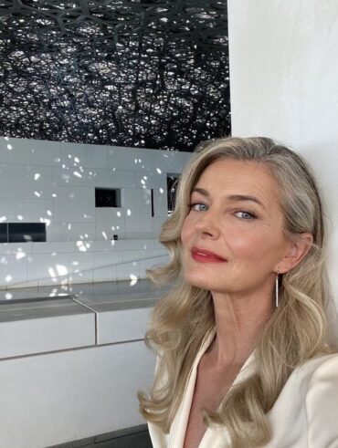 Mulher branca, com blusa branca, cabelo loiro e maquiagem simples