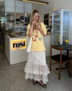 Julia com camiseta estampada, maxi bag branca, saia midi de tule e sapatilha Mary Jane animal print
