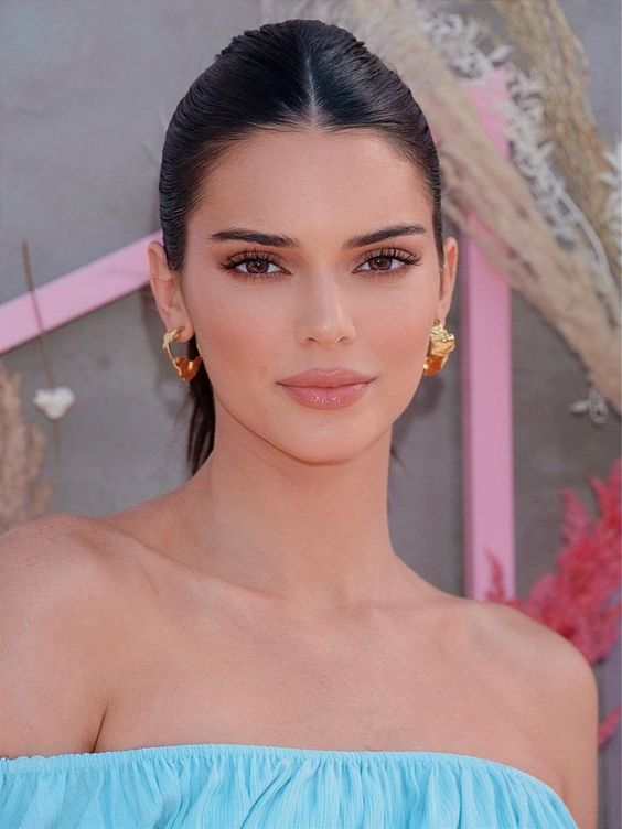 Kendall Jenner, com vestido azul, cabelo preto e sobrancelha reta 