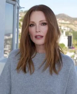 Julianne Moore, com blusa cinza, cabelo ruivo e maquiagem simples