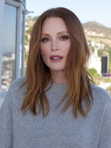 Julianne Moore, com blusa cinza, cabelo ruivo e maquiagem simples