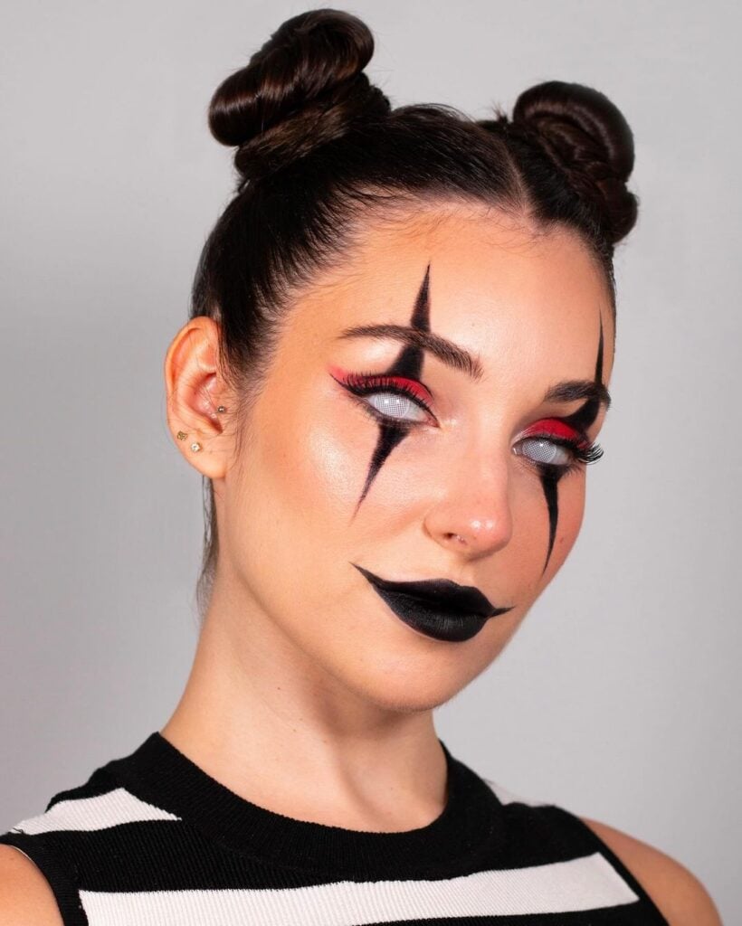 Mulher de pele branca, com regata listrada, dois coques no cabelo e maquiagem de palhaço para o Halloween