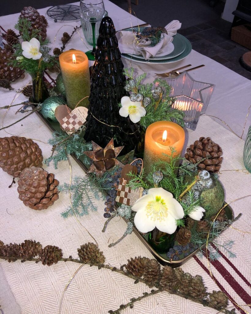 Mesa posta de Natal, com centro de mesa com pinhas, flores e velas