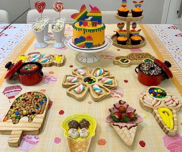 Mesa com toalha de cupcake e muitas guloseimas