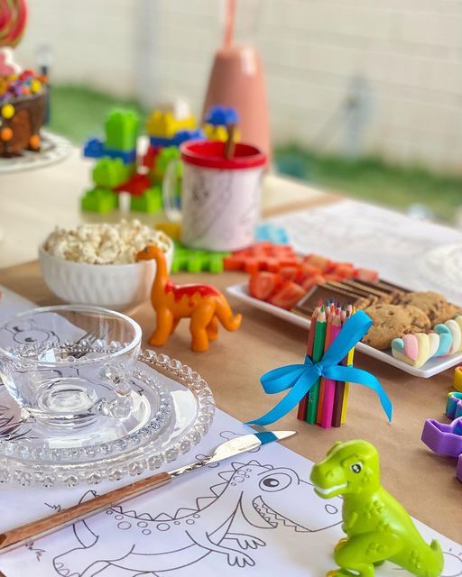 Mesa decorada com dinossauros e lápis de cor
